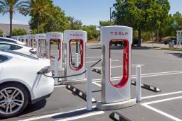 Tesla charging at a Supercharger in a parking lot.